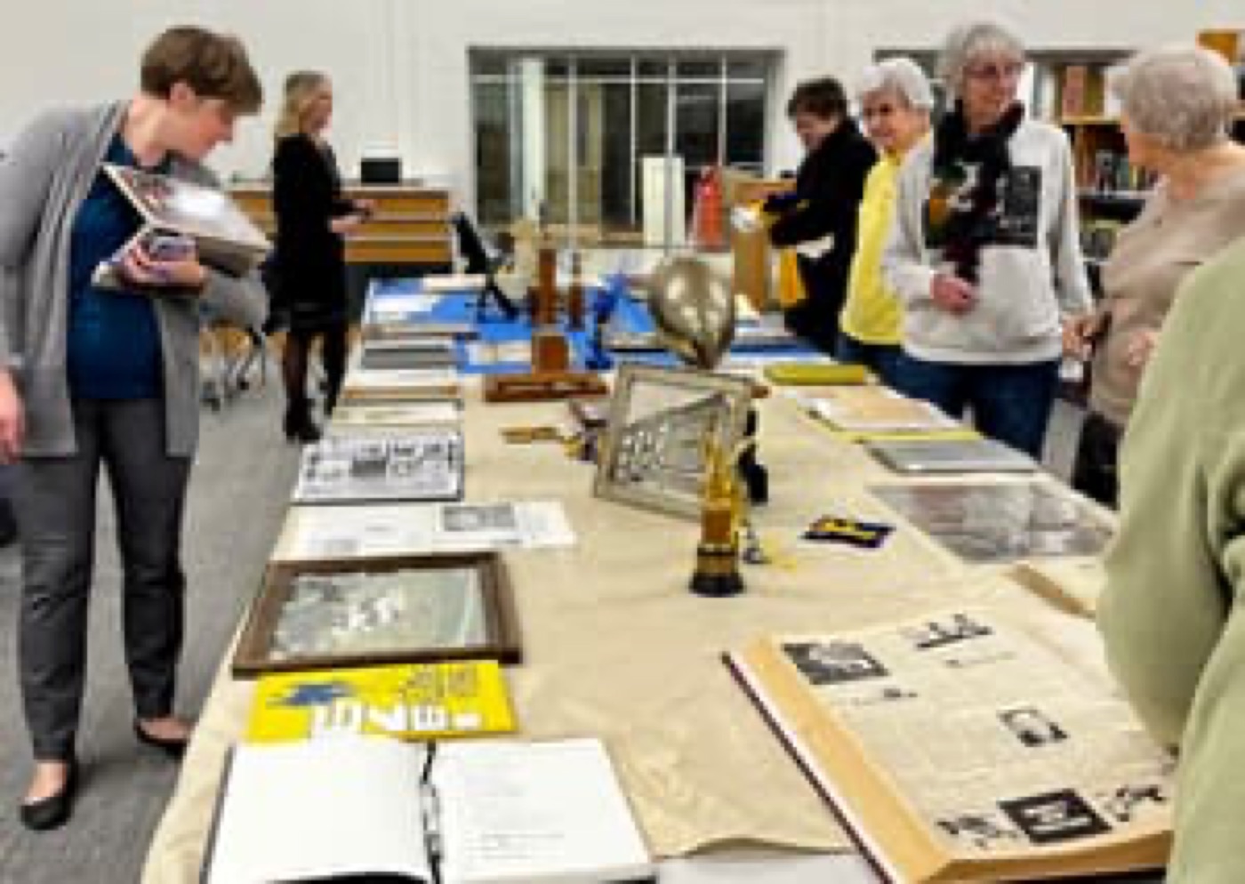 Visitors examining photographs, documents, trophies, and other materials during the 2023 archive open house