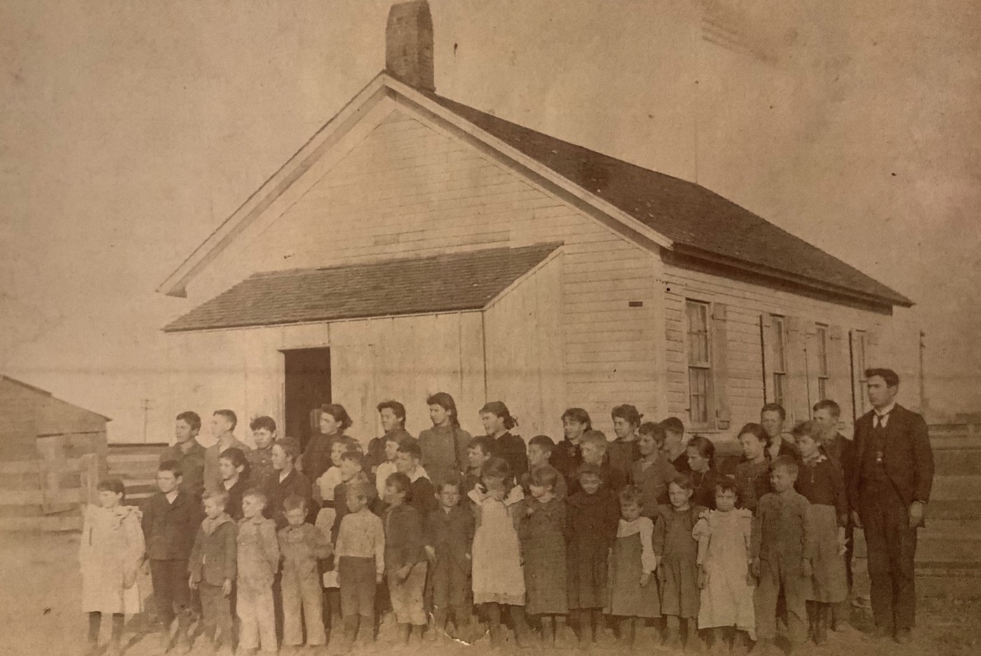 Forsyth students and their teacher posed outside the original schoolhouse